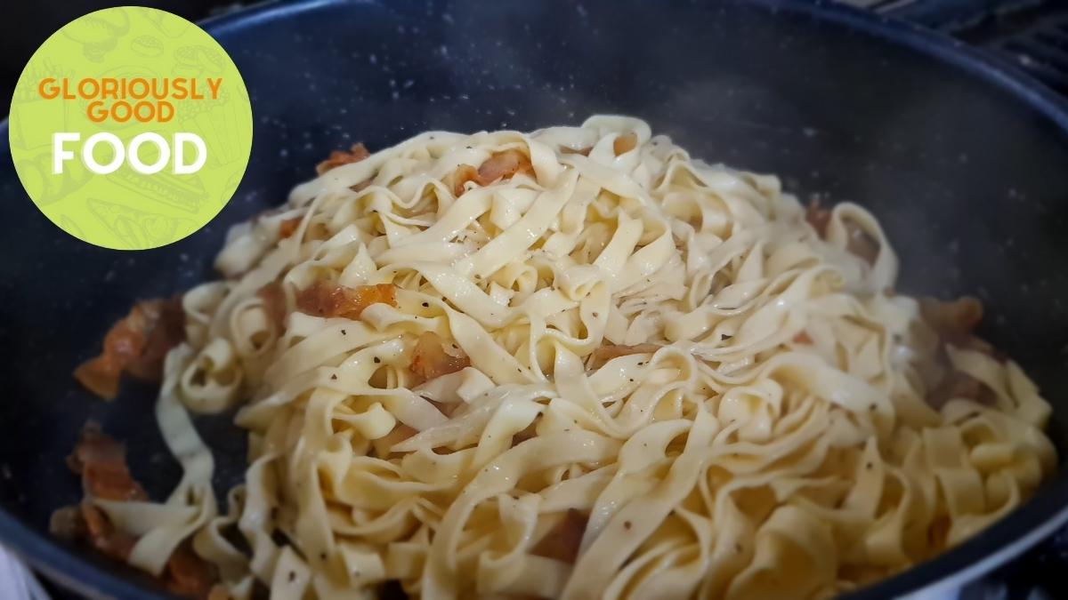 Tagliatelle in the sauté pan with the guanciale and its melted fat